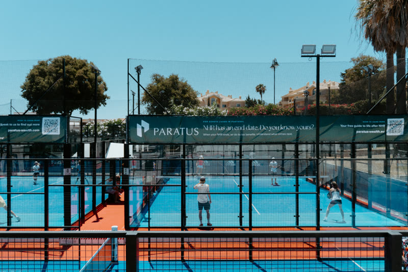 Wide view of the padel courts with a Paratus Wealth banner reading NHR has an end date, do you know yours
